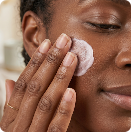 Woman applying skincare product to her face